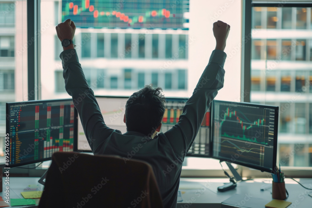 Poster successful stock market trader raising his arms in front of multiple computer screens showing charts