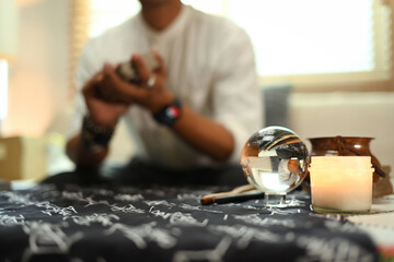 Burning candles, crystal ball and Tibetan singing bowl creating mystical and serene atmosphere ob fortune teller desk