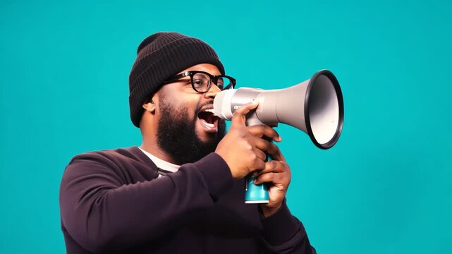 Bearded man in beanie shouting through megaphone - Turquoise background