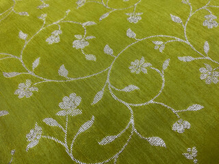 Silver floral woven design on light green silk fabric