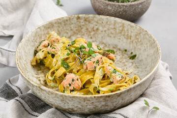 Fettuccine Pasta with Salmon and Cream Sauce in Rustic Bowl on Linen Napkin