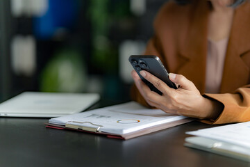 Asian senior business woman using smart phone at office.