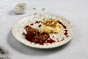 Gourmet Beef Cheeks in Demi-Glace Sauce with Creamy Mashed Potatoes on Rustic Plate