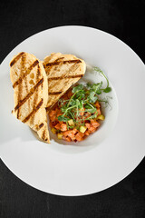 Gourmet Salmon Tartare with Avocado and Grilled Ciabatta on Elegant White Plate