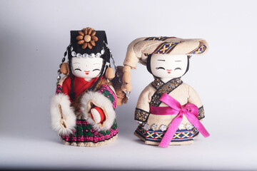 Chinese ethnic minority female and male dolls, isolated in white.