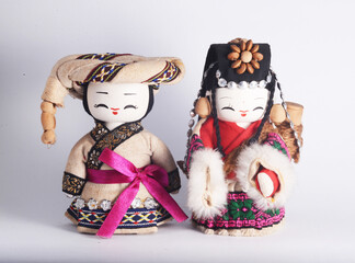 Chinese ethnic minority female and male dolls, isolated in white.