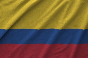 Colombia flag depicted on folded wavy fabric of old cloth close up