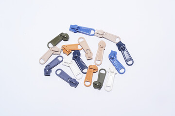 Plastic multi-color zipper sliders or zipper pullers, flat lay, isolated in white.