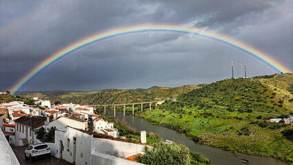 Rainbow over the river Guadiana and the village of Mertola. Alentejo Region. Portugal