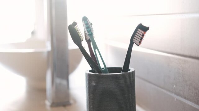 Woman'S Hand Tossing A Toothbrush Into A Cup In The Bathroom As Part Of Her Morning Routine, In Slow Motion