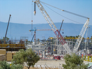 Refinery Under Construction with Heavy Machinery and Building Materials