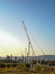 Fototapeta premium Refinery Under Construction with Heavy Machinery and Building Materials