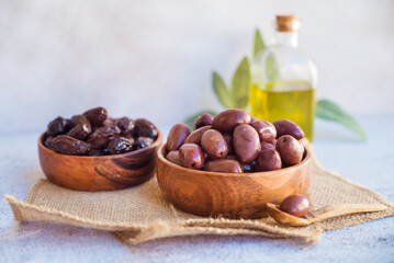 Olives kalamata in wooden bowl and olive oil