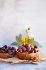 Olives kalamata in wooden bowl and olive oil