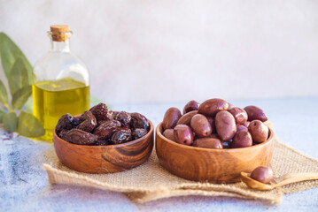 Olives kalamata in wooden bowl and olive oil