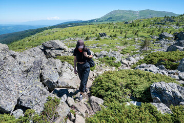 Traveler Woman standing on a rocks in the  summer mountain .Vitosha Mountain ,Bulgaria 