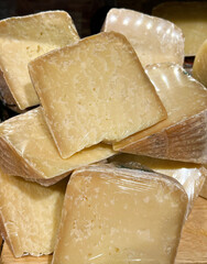Pieces of natural hard cheese in a food shop