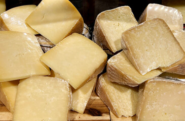Pieces of natural hard cheese in a food shop