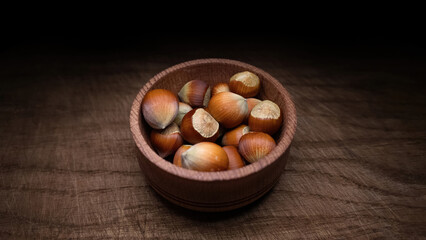 Hazelnuts in shells on a wooden board.