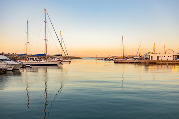 leisure yacht sailboats docked at small harbour in Cape Town at sunset