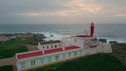 Aerial view cloudy evening horizon over beautiful endless ocean. Red lighthouse