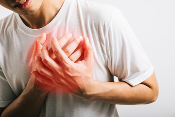 Portrait Asian young man holding his arms around his chest suffering because of a heart attack...
