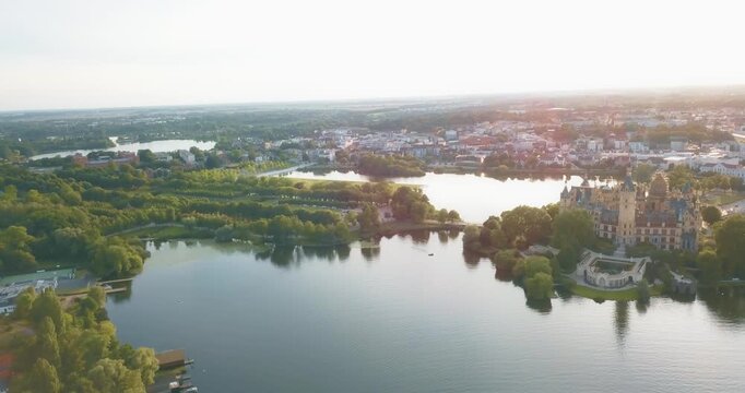 Amazing view over the lakes of Schwerin, historic castle with the Schlosspark in Germany at sunset, slow motion and copy space