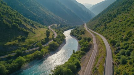 Fototapeta premium Aerial shot of a beautiful road winding beside a river in the lush region of Svanetia, Georgia