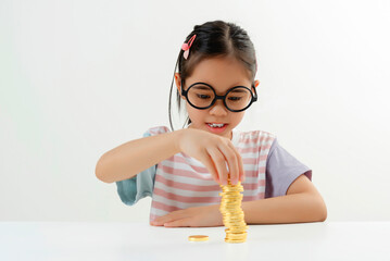 Young Girl Stacking Gold Coins with Focus and Determination