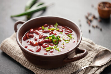 Red bean soup in a ceramic bowl with chili pepper and green onions garnish