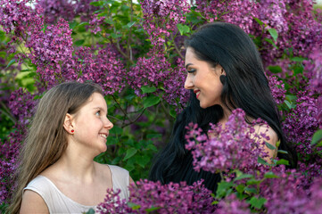 Fototapeta premium Two women in a lilac garden. Shallow depth of feld