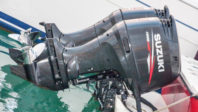 Profile of a pair of outboard marine engines model Suzuki 75 hp four stroke mounted in a white fiberglass boat, Rome 01/07/2024