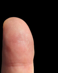 finger on the background. A closeup shot of a human finger skin on a black background. The image of finger close up.