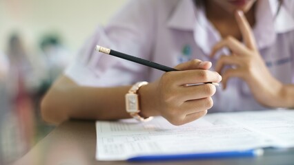 Assessment examination of high school students dressed in uniform.The students were doing the exams inside the classroom with stress.