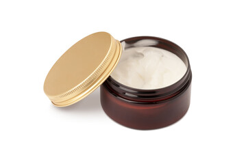 glass jar of hair grooming product for styling hair golden lid resting on the side