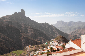 aerial panoramic view on the scenic mountains village Tejeda with white houses and red roofs on...