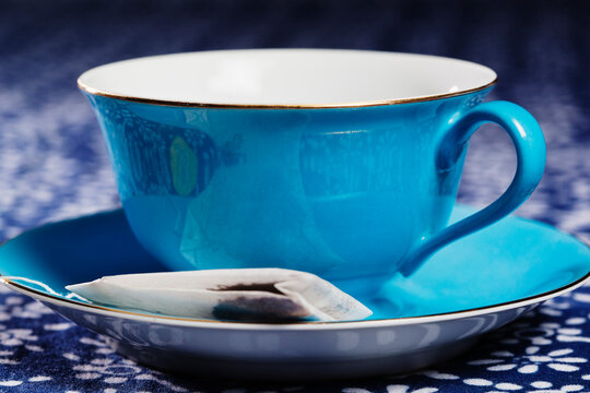 Close up of a blue porcelain teacup with matching saucer.
