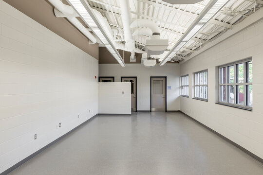 Interior view of a room with white walls and grey vinyl floor in an animal shelter.