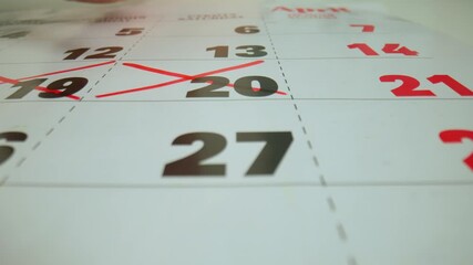 Red marker highlighting crossing out the calendar days of the month on the paper page. Three days being crossed of month in calendar.