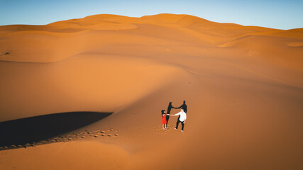 tourist couple they enjoying their Marriage proposal in the middle of the dunes in moroccan Sahara Desert