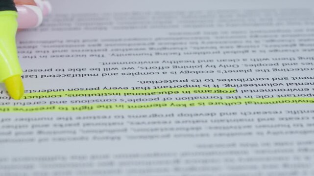 Close up shot of woman hand working with document, yellow marker in female hand marked highlighted an important parts in text.