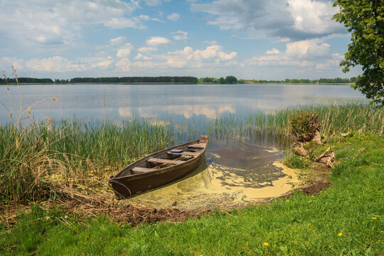 old wooden boat on the shore of the lake.