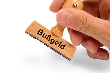 Ein Holzstempel ist beschriftet mit dem Aufdruck: Bußgeld