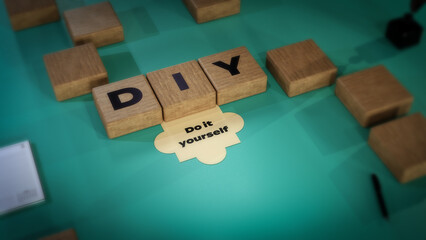 DIY abbreviation of Do it yourself, 3D acronym wood text block concept on green background