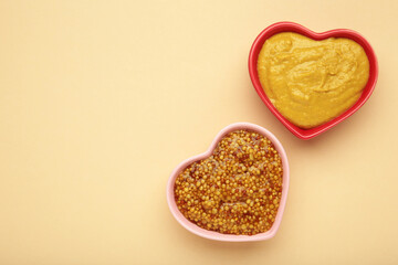 Dijon mustard with french mustard on beige background. Space for text