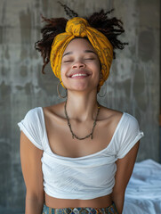 Fototapeta premium Joyful Young Woman in White Top and Yellow Headwrap Smiling in Urban Setting