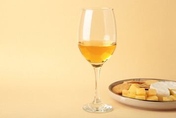 Wine tasting. Parmesan cheese with glass of wine on beige background. Cheese plate. Wine card, rastaurant menu.