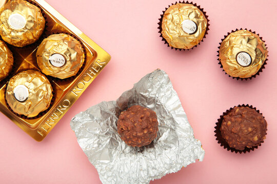 Mykolaiv, UKRAINE - July, 2024 Ferrero Rocher - round chocolates on pink background. Candy in branded packaging, a sweet pleasure for children and adults