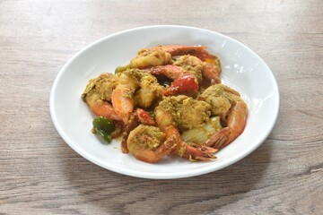 stir fried shrimp with bell pepper and spring onion in yellow curry and egg on plate