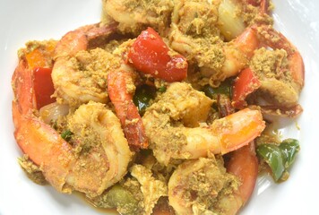 stir fried shrimp with bell pepper and spring onion in yellow curry and egg on plate